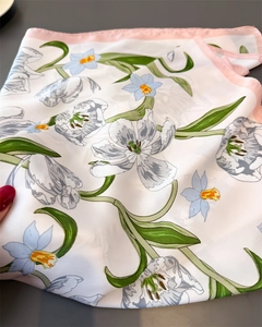 Close-up of silk scarf with pink edges and elegant tulip and narcissus floral pattern
