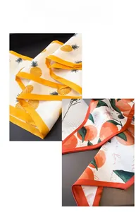 Detailed macro view of the double-layered satin silk scarf with citrus fruit patterns