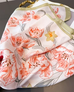 Detail of silk scarf with orange tulips and green borders on an elegant tray