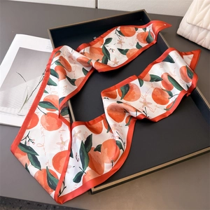 Detail of a white satin twilly scarf featuring citrus prints and red contrast stitching