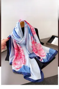 Detail of silk-satin scarf featuring lotus floral print and deep blue hemmed edges