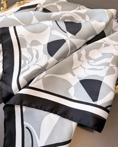 Detail of silk-like satin scarf featuring rose floral patterns and geometric borders