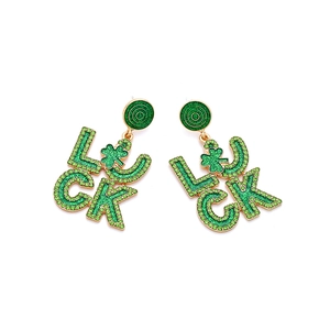 Detail von goldenen Ohrringen mit grünen Strasssteinen und Kleeblatt für St. Patrick's Day