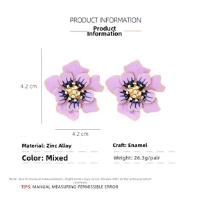Détail des boucles d'oreilles fleurs en émail avec cristaux et alliage de zinc