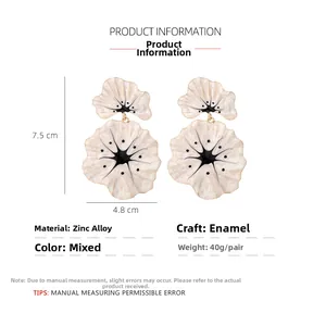 Detail view of large enamel flower earrings in cream white with black line accents