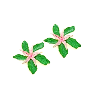 Détail des boucles d'oreilles fleurs en émail avec pétales verts et bords dorés