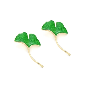 Macro detail of enamel ginkgo leaf earrings with golden metallic veins and textures