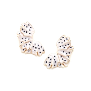 Detail view of multi-layered leaf earrings with black polka dots on white enamel