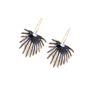 Close-up of fan-shaped enamel earrings with black and white marble texture and gold hooks