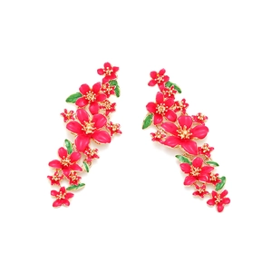 Détail de boucles d'oreilles fleuries en émail rose avec feuilles vertes vives