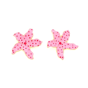 Vue détaillée des boucles d'oreilles fleurs en émail rose avec pois rouges et bord doré
