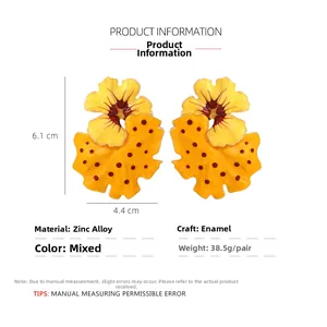 Detail view of yellow enamel flower earrings with brown dots and 6.1x4.4cm dimensions