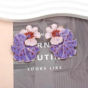 Detailed macro view of enamel flower earrings featuring pink and purple tiered petals