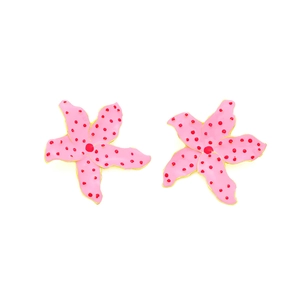 Détail de boucles d'oreilles étoile de mer rose à pois rouges et bordure dorée