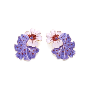 Detail of enamel floral earrings with purple polka dot petals and golden edging