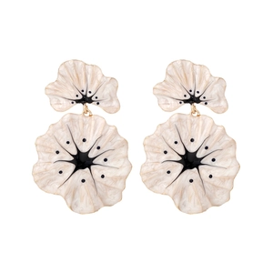 Exaggerated floral drop earrings with white enamel petals and gold edges on white background