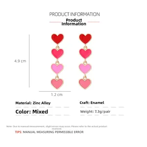 Detail view of tiered gradient pink enamel heart earrings with size measurements