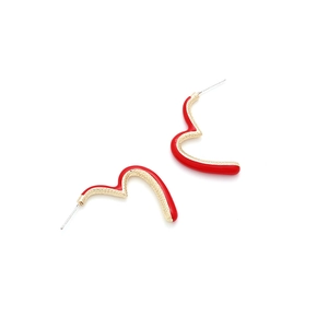 Boucles d'oreilles cœur en émail rouge et métal doré martelé sur fond blanc épuré