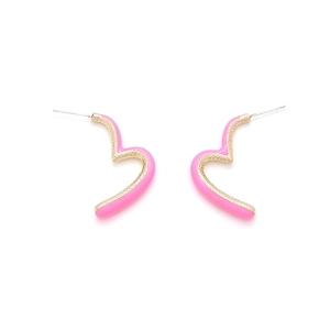 Détail de boucles d'oreilles cœur en émail rose avec bord doré sur fond blanc pur