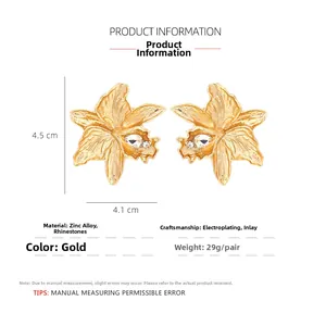 Détail macro de boucles d'oreilles fleur dorée avec cristaux, taille 4,5cm x 4,1cm