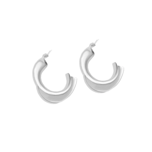 Detailed close-up of silver-tone C-shape earrings with twisted geometric design