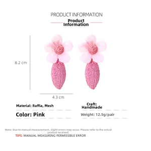 Détail de boucles d'oreilles fleurs en raphia rose et tulle avec dimensions de 8,2cm