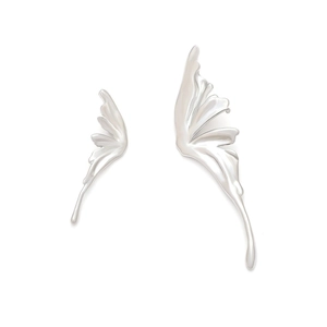 Macro detail of liquid silver butterfly earrings showing asymmetric metal wings texture