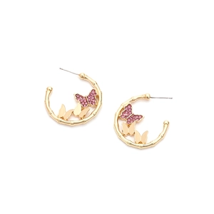 Detail of C-shaped gold bamboo earrings with pink rhinestone and gold butterfly charms