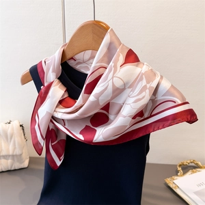 Detail of silk square scarf with abstract rose floral print draped on a hanger
