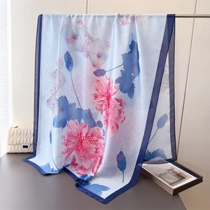 Close-up of lightweight silk satin scarf with pink lotus print and dark blue border