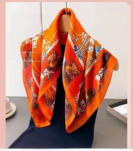 Detail of silk scarf featuring classic carriage print in vibrant orange on a hanger