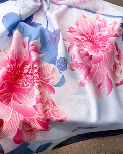 Detailed view of silky scarf fabric with vibrant pink and blue floral print and satin sheen