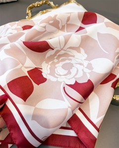 Macro detail of red rose print silk scarf with satin texture on vintage gold tray