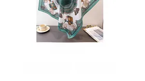 Detail of silk scarf with classic carriage print, styled with coffee cup and magazine