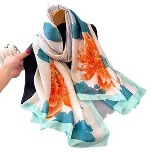 Elegant ivory faux silk scarf with orange and cyan floral prints on a black hanger