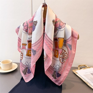 Elegant silk square scarf with horse carriage print hanging on a wooden hanger