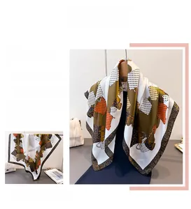 Detailed view of the leopard print and geometric pattern on a square silk-like scarf