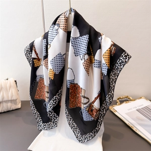 Elegant silk-like scarf with leopard print and polka dots draped on a mannequin