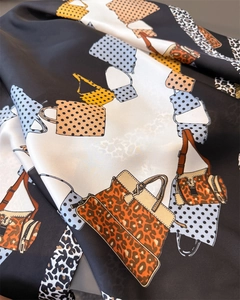 Detailed view of leopard print faux silk scarf with elegant handbag illustrations and dots
