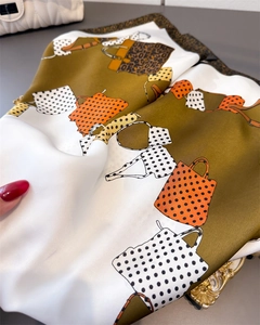 Detailed view showing the soft texture and leopard print of the olive green silk scarf
