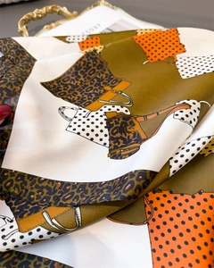 Detail of silk leopard print scarf with bold patterns on a gold vintage tray