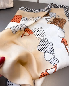 Detail of elegant satin square scarf with leopard print, polka dots and handbag motifs