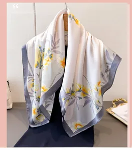 Détail d'un élégant foulard en soie à fleurs jaunes avec des bordures gris foncé