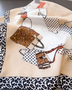 Detail of silk scarf showing leopard print borders and stylish handbag illustrations