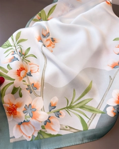 Détail d'un foulard en satin aux motifs floraux montrant la texture soyeuse chic