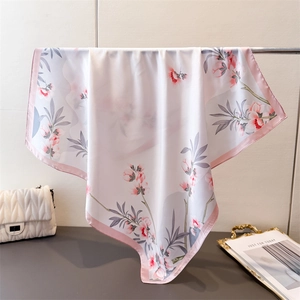 Détail d'un foulard effet soie avec imprimés floraux roses et drapé élégant de luxe