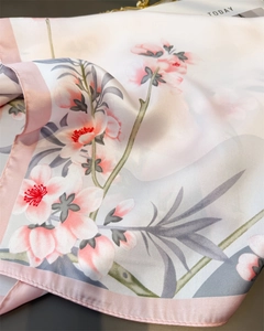 Gros plan du foulard en soie avec imprimé fleurs de pêcher et bordure rose finie