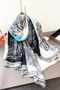 Nahaufnahme des leichten Seidenschals mit Paisley-Muster und elegantem blau-weißem Fall