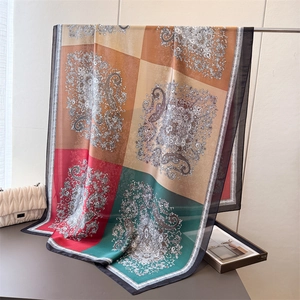Detailansicht eines Seidenschals mit Paisley-Muster in Rot, Grün und Orange