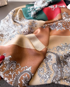 Detail eines weichen Paisley-Seidenschals mit kräftigen Farben und glatter Textur
